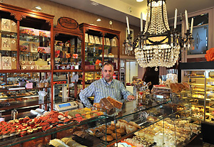Patisserie en Chocolaterie J.C. Beune Eigenaar Gerard Rombouts voor het laatst achter de toonbank van J.G. Beune. Foto: www.winkelstories.com  