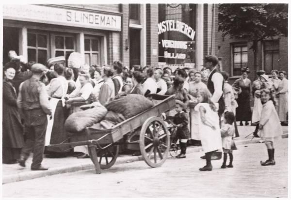 De winkel van 'Ome Simon' aan de Jacob van Lennepkade z.d. (1914-1918)  <p>Tijdens WOI waren aardappelen op de bon en stonden er lange rijen voor de winkel. </p>