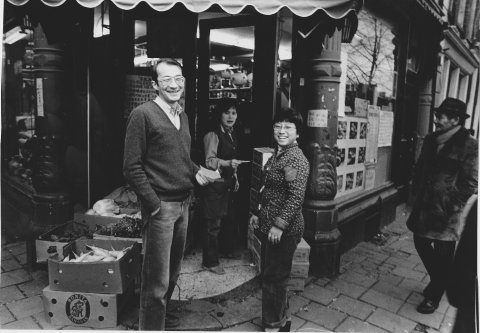 Dun Yong-01  <p>Henko Dun en zijn vrouw Wai Ming voor hun winkel op de hoek van de Geldersekade en de Stormsteeg, Foto Dolf Toussaint. Plm 1978.</p>