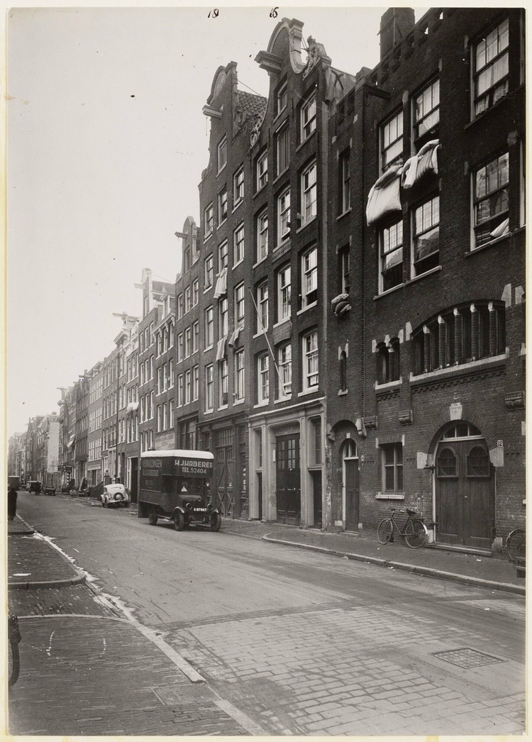 Nieuwe Kerkstraat nummer 14 – 20 met synagoge, met beddengoed dat hangt te luchten (nov. 1940). Bron: Bureau Monumentenzorg, glasnegatieven SAA.  